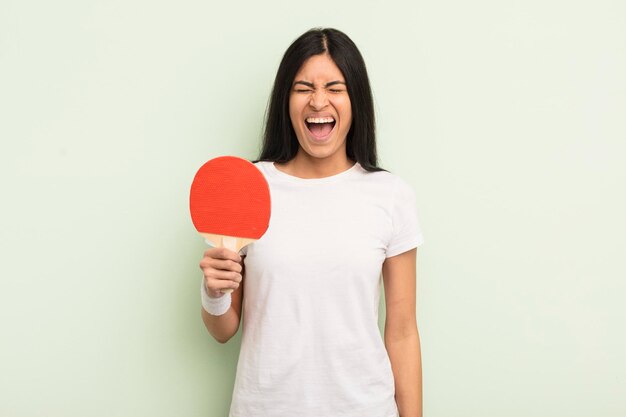 Young pretty hispanic woman shouting aggressively looking very angry ping pong concept