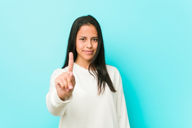 Young pretty hispanic woman showing number one with finger.