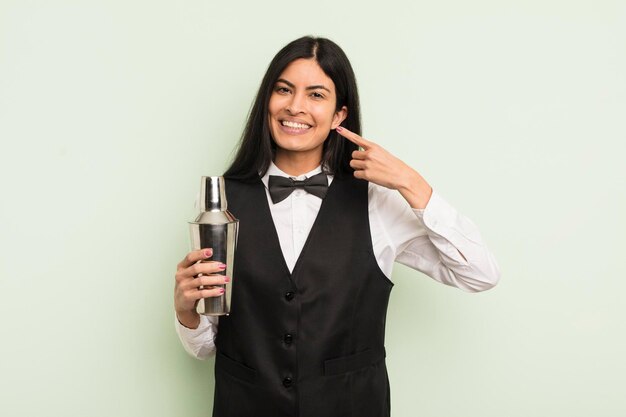 Young pretty hispanic woman smiling confidently pointing to own broad smile cocktail bartender concept