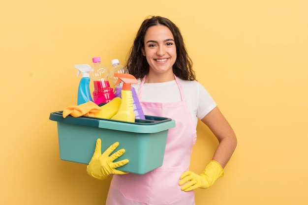 Young pretty hispanic woman smiling happily with a hand on hip and confident housework an clean products concept