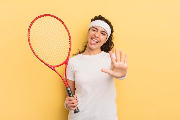 Young pretty hispanic woman smiling and looking friendly showing number five tennis concept