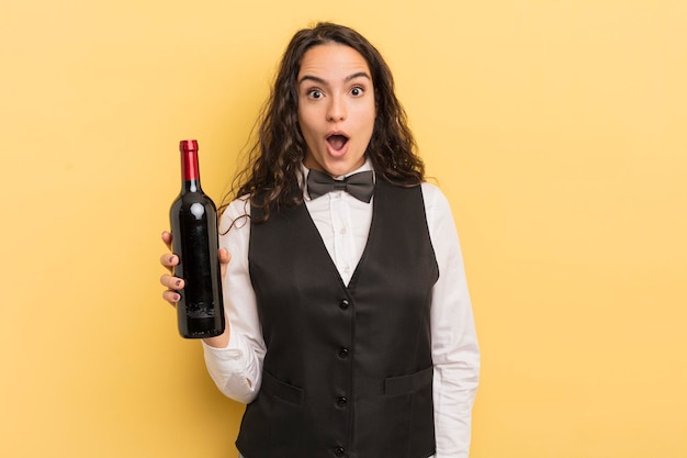 Young pretty hispanic woman waiter with a bottle of wine