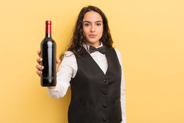 Young pretty hispanic woman waiter with a bottle of wine