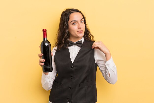 Young pretty hispanic woman waiter with a bottle of wine