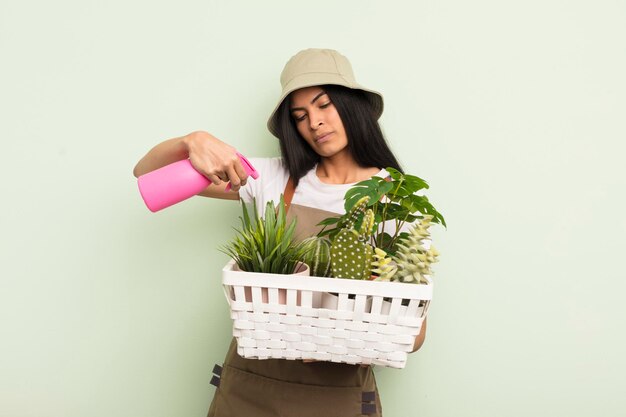 Young pretty hispanic woman with plants farmer or gardener concept