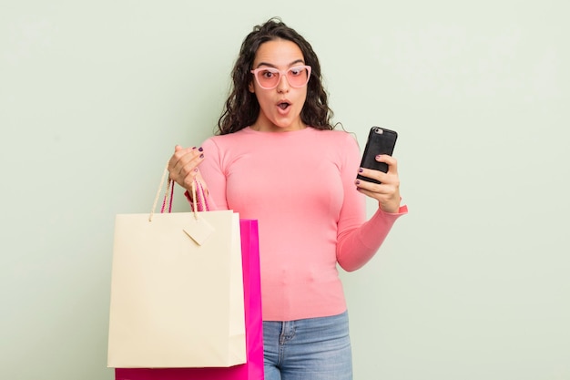 Young pretty hispanic woman with shopping bags