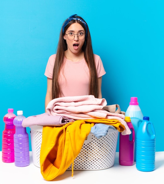 Young pretty house keeper looking very shocked or surprised, staring with open mouth saying wow