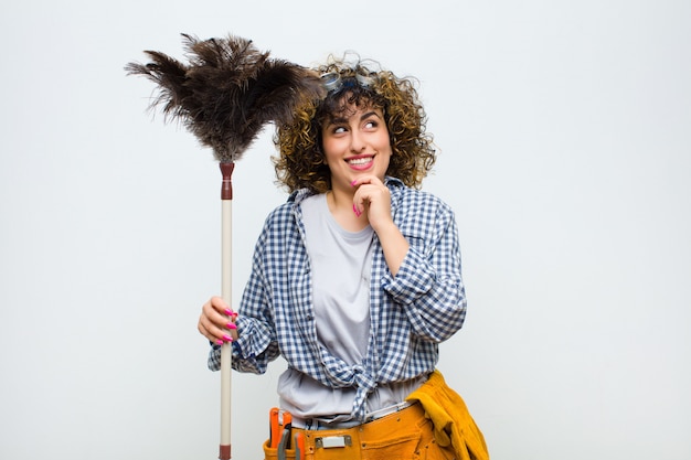 Young pretty housekeeper woman with a duster