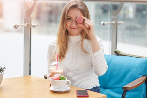 Young pretty lady in white shirt sits at table on blue sofa