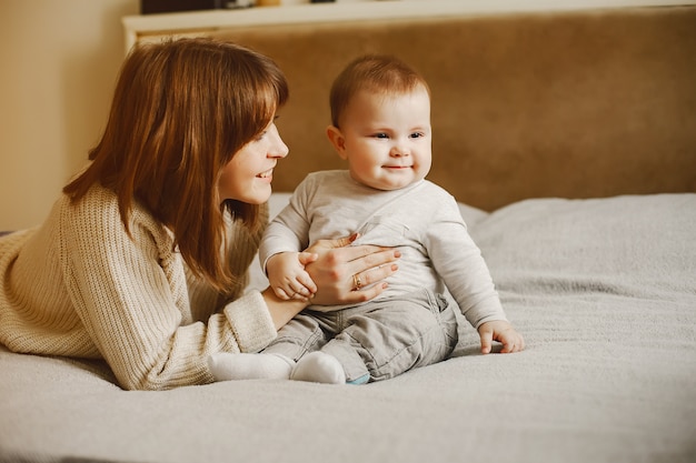 young and pretty mother playing with her son at home