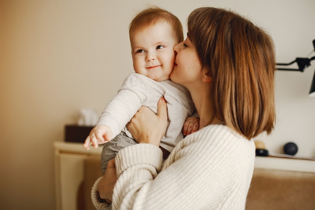 young and pretty mother playing with her son at home