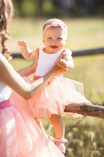 Young pretty mother with her little baby outdoors. Beautiful woman with her daughter on the nature. infant child with her parent