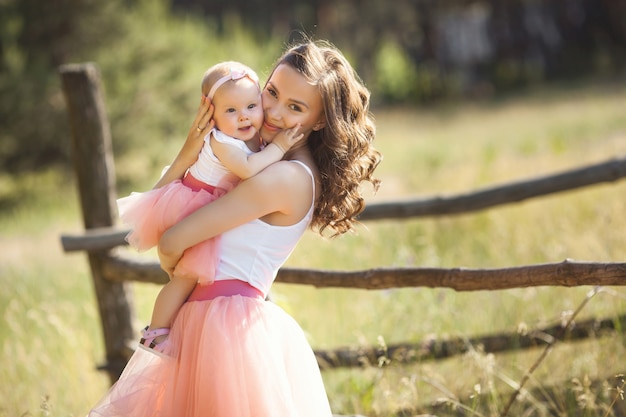 Young pretty mother with her little baby outdoors. Beautiful woman with her daughter on the nature. infant child with her parent