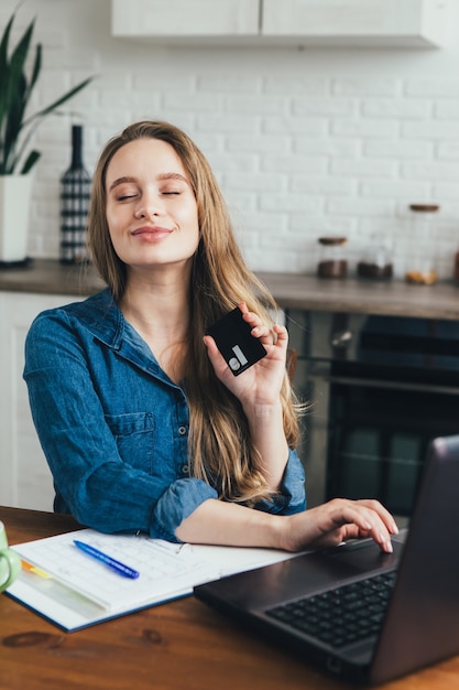 Young pretty pregnant girl works at home in self-isolation mode in quarantine and makes online purchases