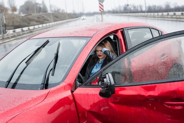 Young pretty scared woman in the car. Injured woman feeling bad after having a car crash