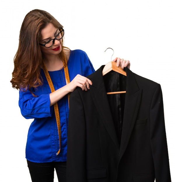 Young and pretty seamstress with tape measure and a suit