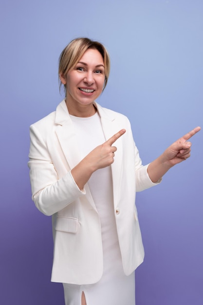 Young pretty slim blond boss woman in a white jacket and dress points her finger at the project