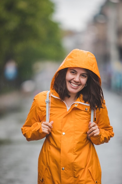Photo young pretty smiling woman portrait in raincoat with hood
