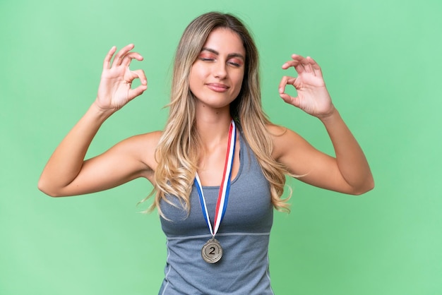 Young pretty sport Uruguayan woman with medals over isolated background in zen pose