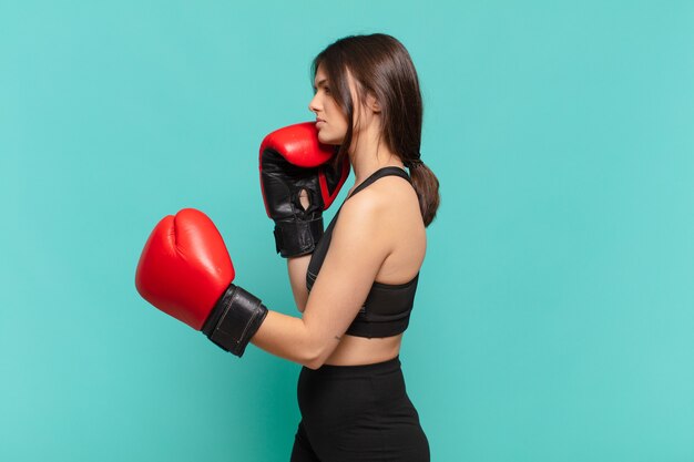 Young pretty sport woman angry expression and a boxing gloves