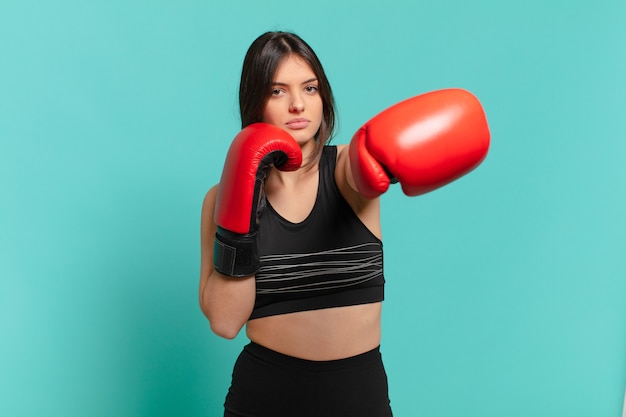 Young pretty sport woman angry expression and a boxing gloves