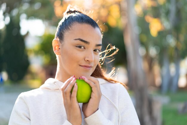 Young pretty sport woman holding an apple