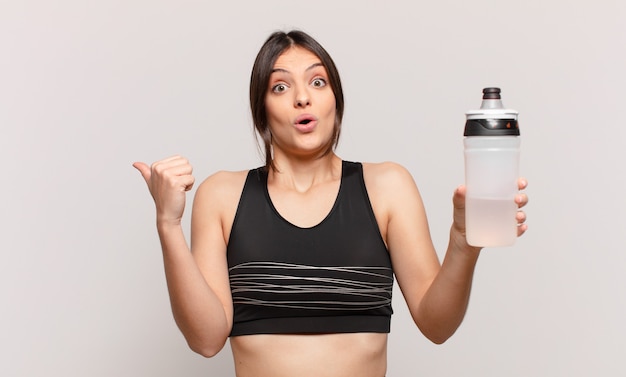 Young pretty sport woman scared expression and holding a water bottle drink