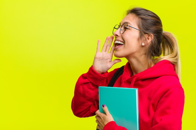 Foto vista di profilo del giovane studente grazioso che sembra gridare felice ed emozionante e che chiama per copiare spazio dal lato