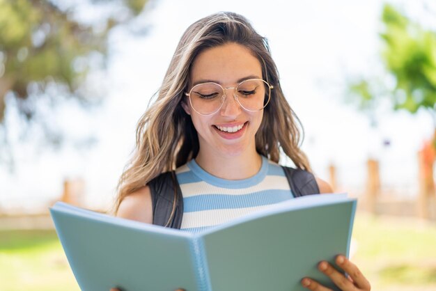 屋外で若いかわいい学生女性