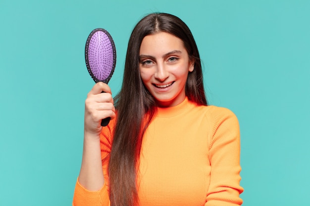 Young pretty teenager girl. happy and surprised expression. hair brush concept