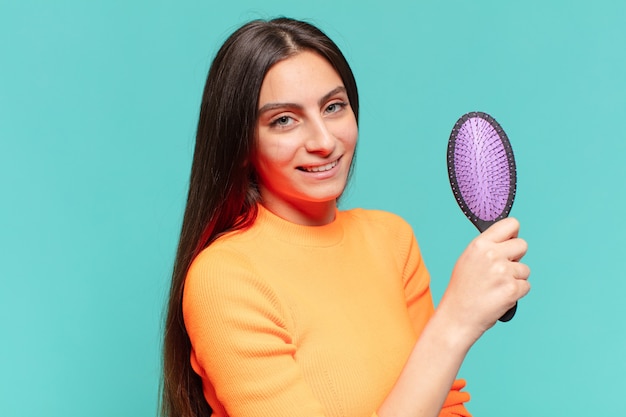 Young pretty teenager girl. happy and surprised expression. hair brush concept