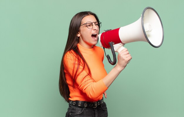 Young pretty teenager girl  megaphone concept