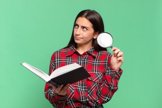 Young pretty teenager girl. searching in a book concept