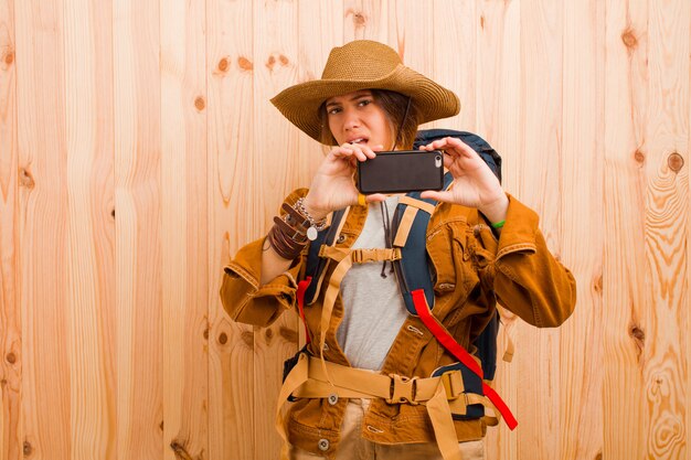 Foto giovane donna graziosa del viaggiatore con un telefono cellulare