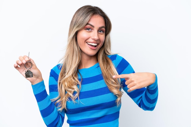 Young pretty Uruguayan woman holding home keys isolated on white background with surprise facial expression