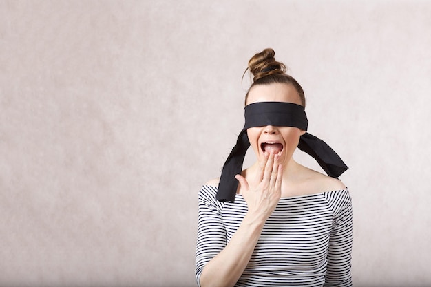 Foto una giovane donna carina tra i 30 ei 40 anni con gli occhi bendati che chiede aiuto