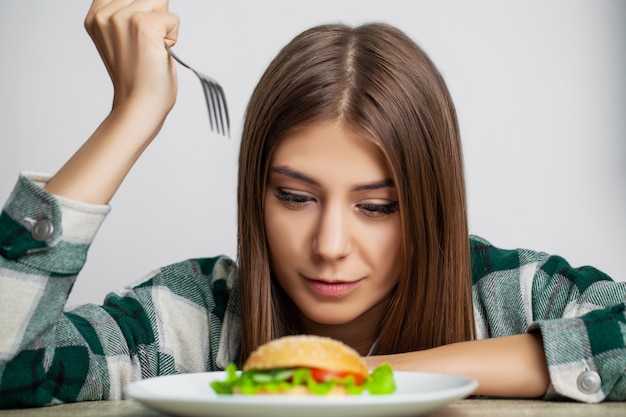 젊은 예쁜 여자는 다이어트를 준수하지만 건강에 해로운 음식을 선택