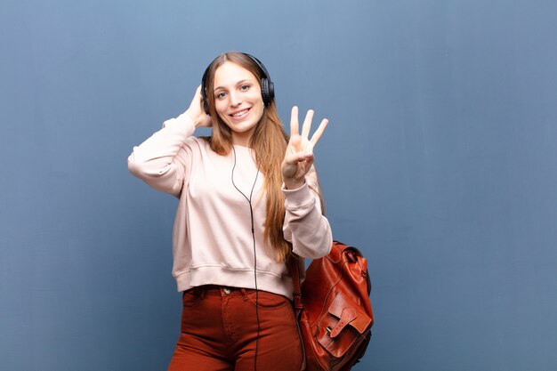 Young pretty woman against blue wall with a copy space