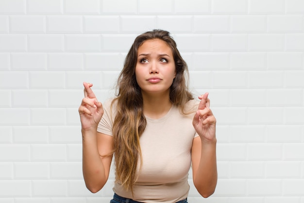 young pretty woman against white wall