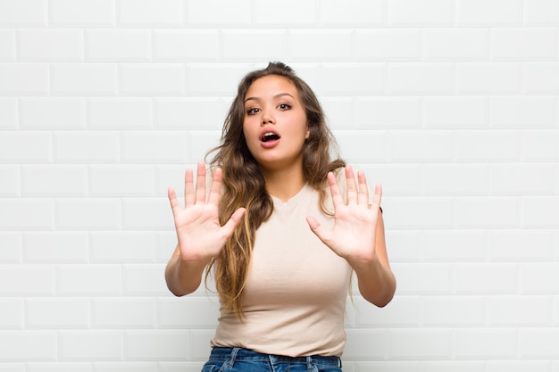 young pretty woman against white wall