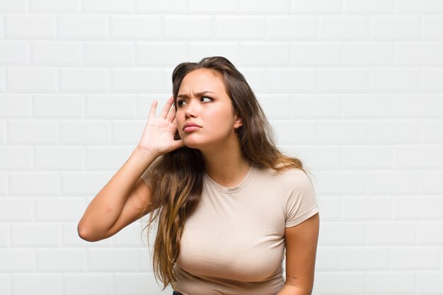 Foto giovane donna graziosa contro il muro bianco