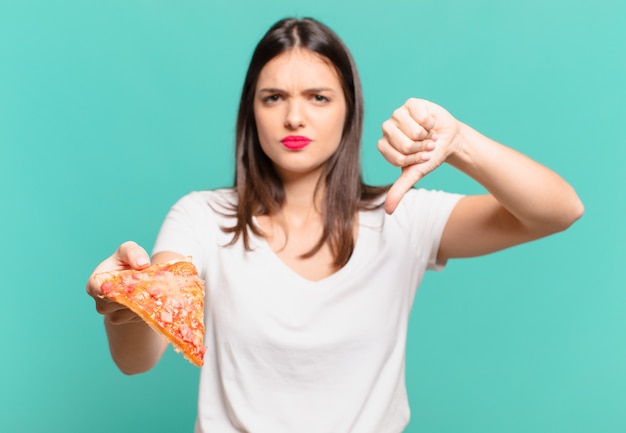 Young pretty woman angry expression and holding a pizza