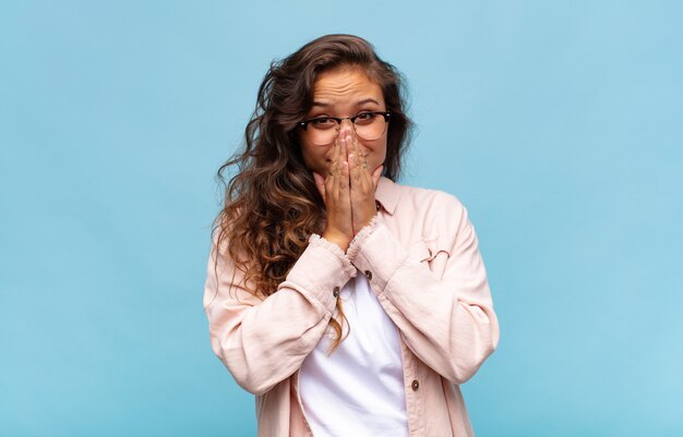 young pretty woman on blue background with glasses