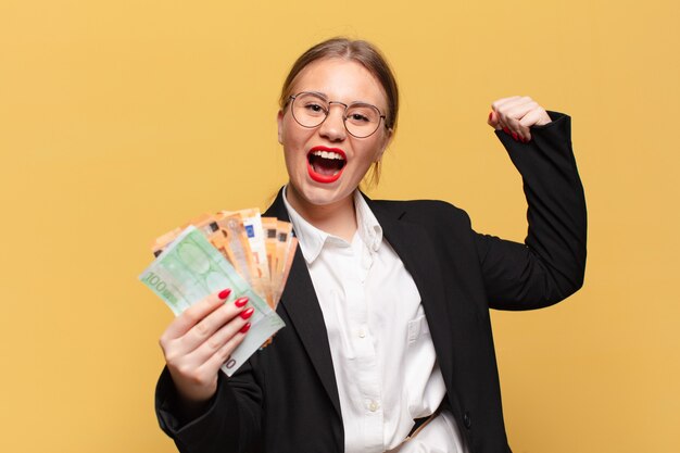 Young pretty woman celebrating a success euro banknotes concept