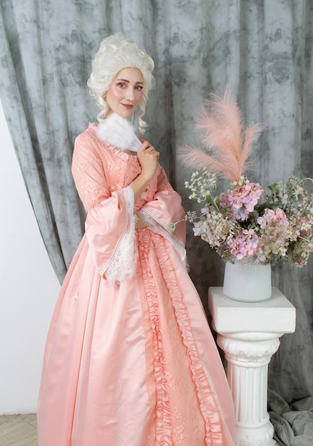 Primo piano della giovane donna graziosa in vestito reale rosa marie antoinette cosplay