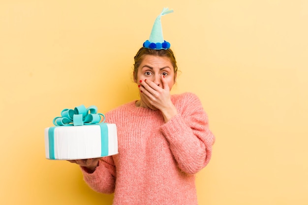 Foto giovane donna graziosa che copre la bocca con le mani con un concetto di compleanno scioccato