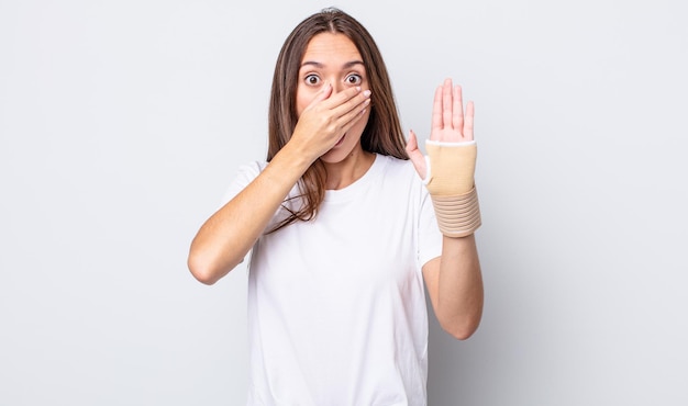 Young pretty woman covering mouth with hands with a shocked. hand bandage concept