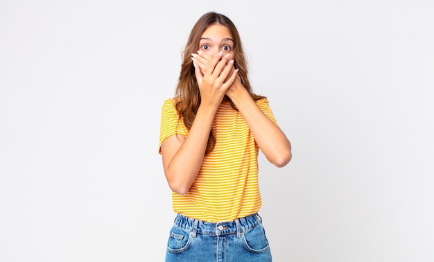 Young pretty woman covering mouth with hands with a shocked