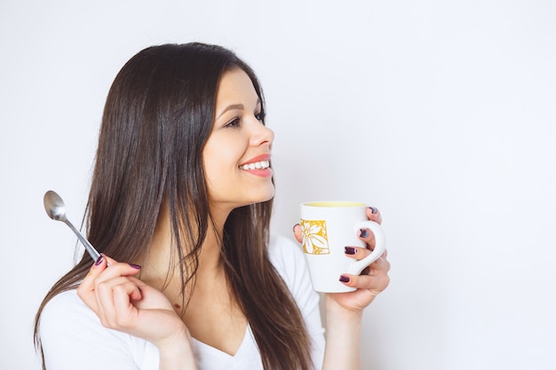 Young pretty woman drinking coffee or tea e.