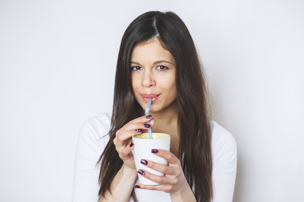 Young pretty woman drinking coffee or tea